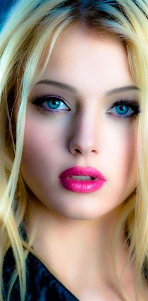 A Blonde Woman With Blue Eyes And Pink Lipstick On Her Lips Is Posing