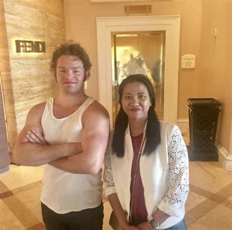 The Man And Woman Are Posing For A Photo In Front Of A Hotel Lobby Door