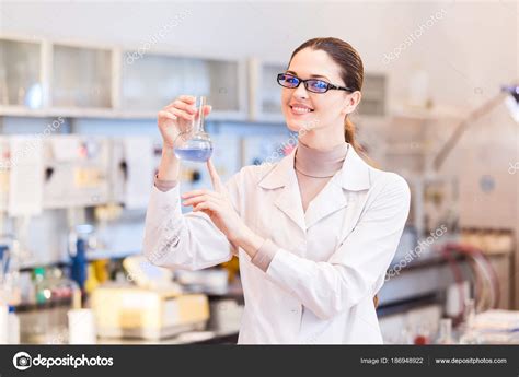 Woman scientist in laboratory with beaker posing — Stock ...