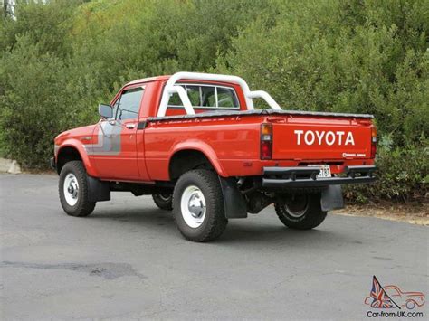 An Old Red Toyota Pickup Truck Parked On The Street