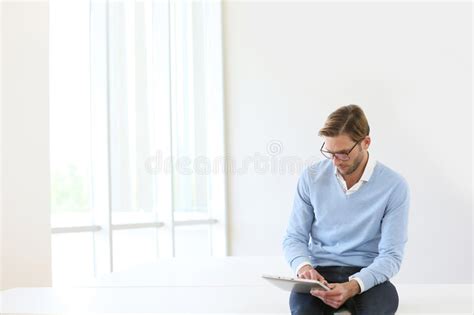 Young Businessman Sitting On Desk Using Tablet Stock Image Image Of