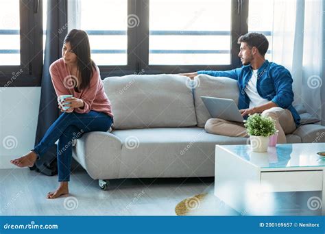 Angry Young Couple Sitting On Couch Together And Looking To Opposite Sides At Home Stock Image