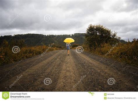 Beautiful Woman Hold Yellow Umbrella And Walks On A