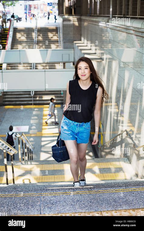 Smiling Young Woman With Long Brown Hair Walking Up A Stairway Stock
