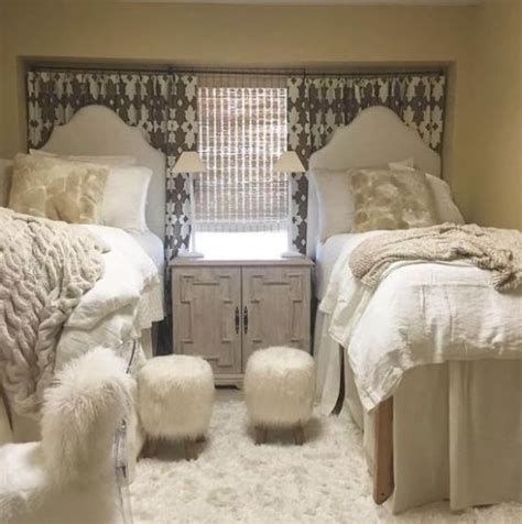 Two Twin Beds In A Bedroom With White Fur On The Covers And Footstools
