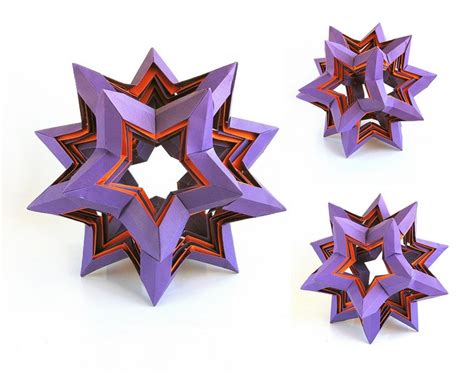 Three Origami Stars Are Shown On A White Surface One Is Purple And The