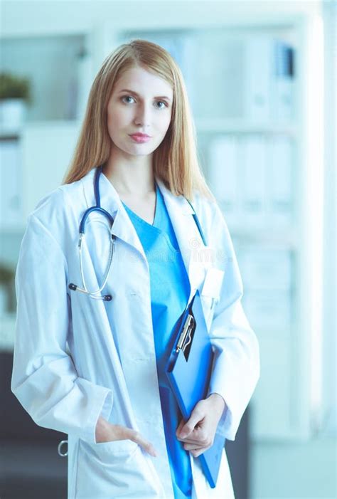 Portrait Of Woman Doctor With Folder At Hospital Corridor Stock Image