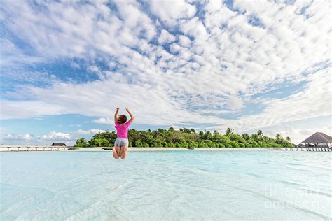 Happy Woman Jumping For Joy In Ocean On Tropical Island In Maldives Photograph By Michal