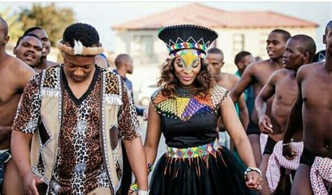 Bride In Black Zulu Attire With Beaded Belt Cape And Black Isicholo Hat Zulu Groom In Leopard