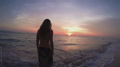 Woman Entering The Sea At The Sunset By Stocksy Contributor