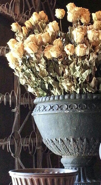 Dried Rosesin Urn Paired With Brown Bowlall Set Against Wall Art