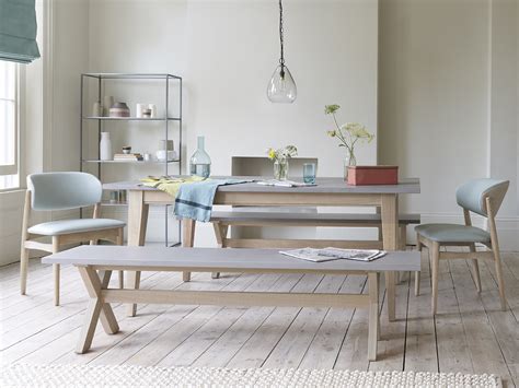 This simple yet striking dining table has a solid, concrete top supported by an intricate framework made of solid wood underneath. Conker | Concrete Top Kitchen Table | Loaf