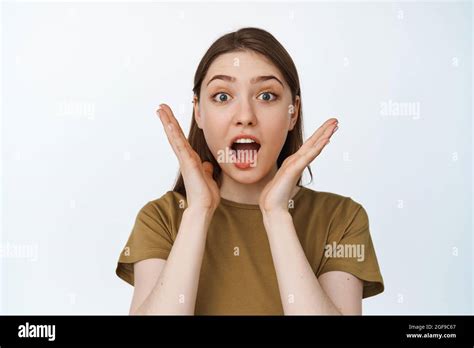 Close Up Of Young Woman Shouting Surprised Gasping In Awe And Staring