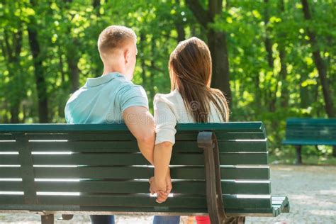 Couple Sitting On Bench Together And Holding Hands Stock Photo Image