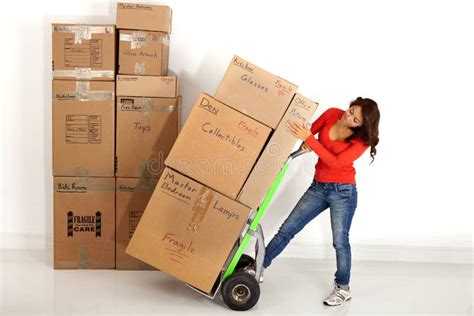 Young Woman Moving Boxes With With A Hand Truck Or Dolly Stock Photo
