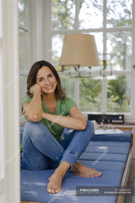 Smiling Mature Woman Sitting On Couch At Home — Window T Shirt Stock