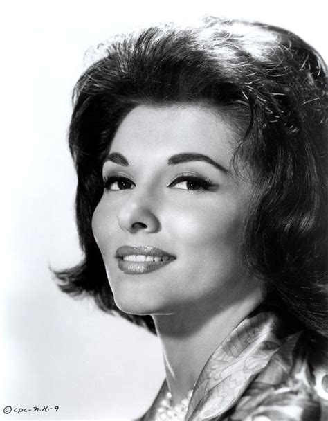 An Old Black And White Photo Of A Woman With Short Hair Wearing A Shiny