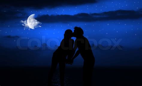 Happy Couple Romantically Kissing At Night Under Moonlight Stock