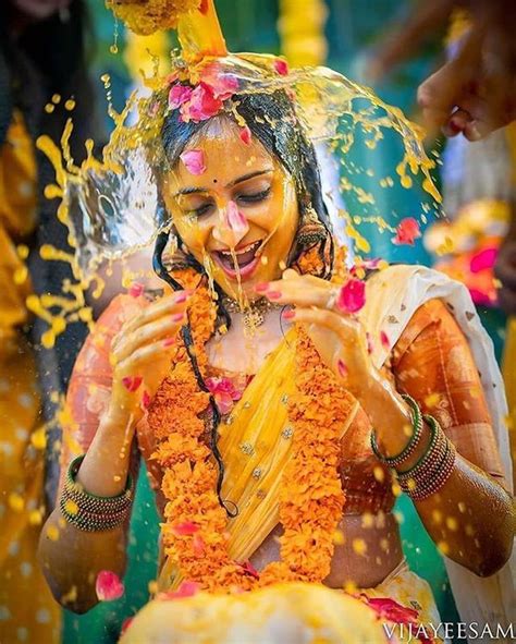 A Woman Covered In Orange And Yellow Powder Throwing Confetti On Her Face As She Smiles