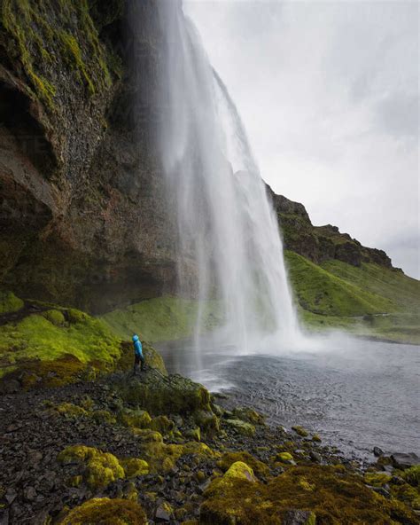 Hiker Looking Up At Seljalandsfoss Waterfall Stock Photo
