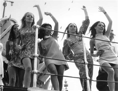 Four Women Are Standing On The Deck Of A Boat And One Is Holding Her Arms In The Air