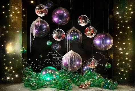 Christmas Ornaments Hanging From The Ceiling In Front Of A Black