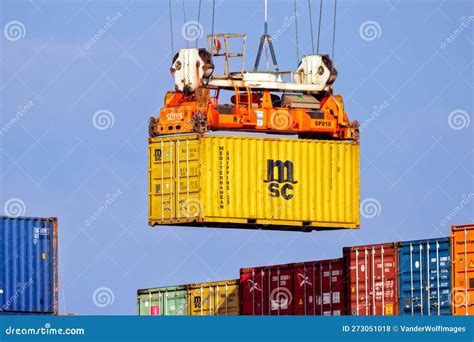 Crane Operator Unloading A Sea Container From A Cargo Ship In The Port