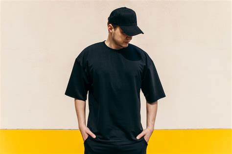 Premium Photo Man Wearing Black Tshirt And A Black Baseball Cap With On An Outdoors Wall