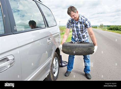 Man Changing A Spare Tire Of Car On Road Stock Photo Alamy