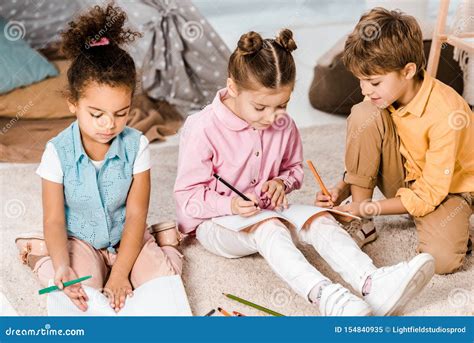 Adorable Multiethnic Children Sitting On Carpet And Stock Image Image