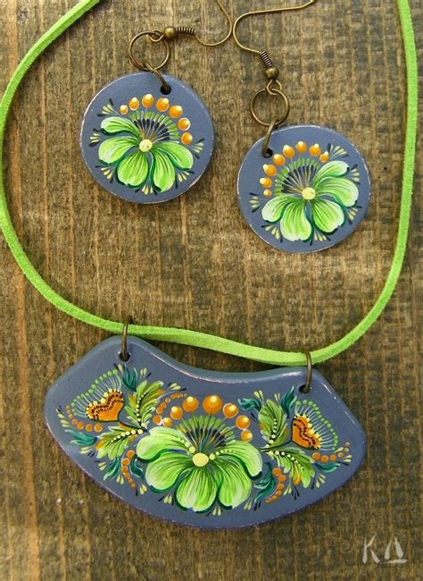 Two Necklaces And Earring With Flowers Painted On Them