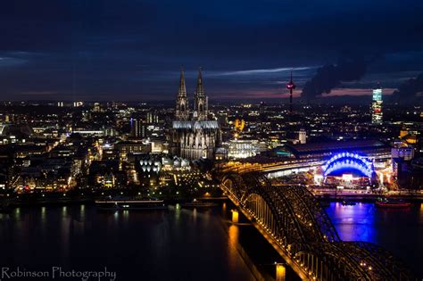 An Aerial View Of A City At Night With The Lights On And Bridges Lit Up