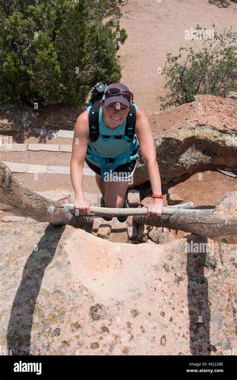 Woman Climbing Ladder In Bandelier National Monument Stock Photo Alamy