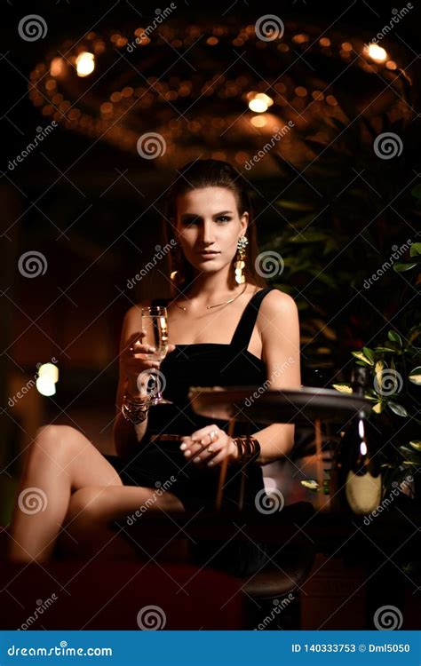 beautiful fashion brunette woman in bar restaurant relaxing drinking champagne wine stock image