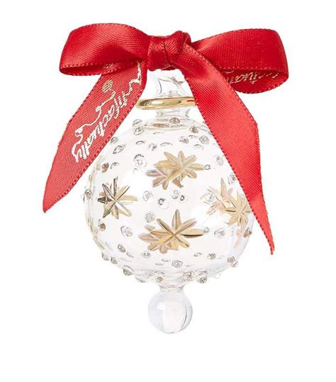 A Glass Ornament With A Red Ribbon Around Its Neck And Snowflakes On