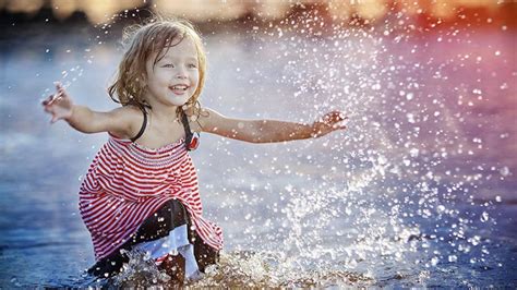 Cute Little Girl Is Playing On Body Of Water During