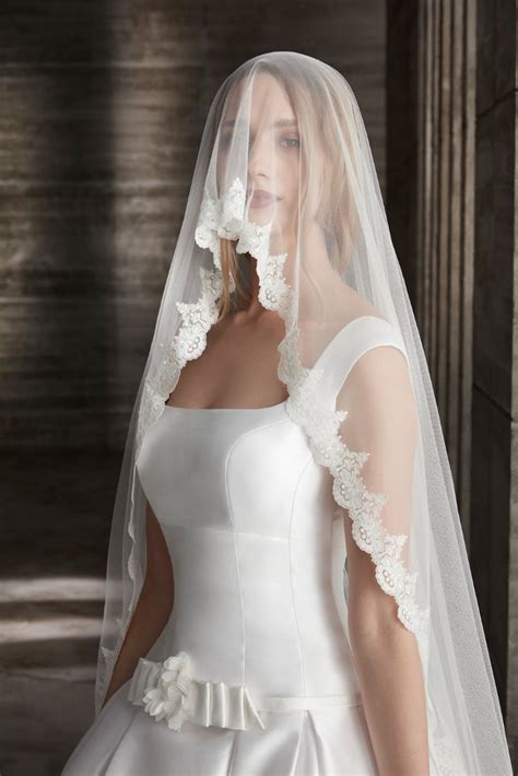 A Woman Wearing A White Wedding Dress And Veil