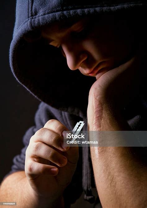 Man Holding A Razorblade To The Scar On His Arm Stock Photo Download
