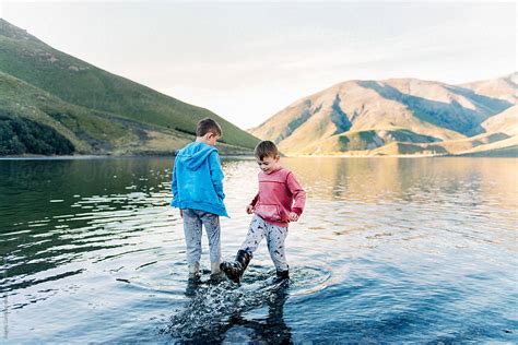 Two Children Playing In The Shallows Of A Mountain Lake Del