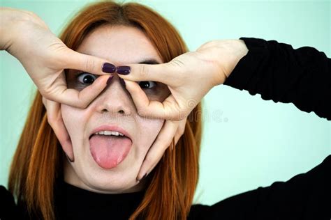 Funny Pretty Redhead Girl Showing Glasses Sign With Her Fingers Stock