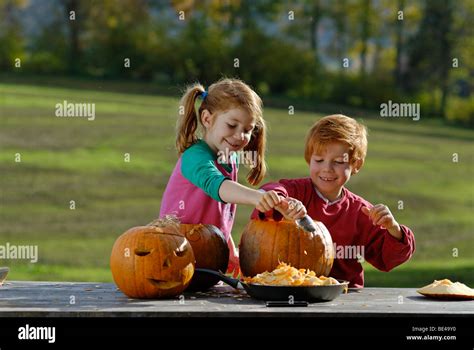 Two Children Carving Pumpkins For Halloween Decoration Stock Photo Alamy