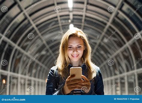 Woman In The City At Night Holding Smartphone Texting Stock Photo