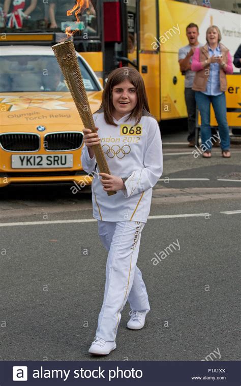 A Torch Bearer Carrying The Olympic Torch Through Penrith Town Centre