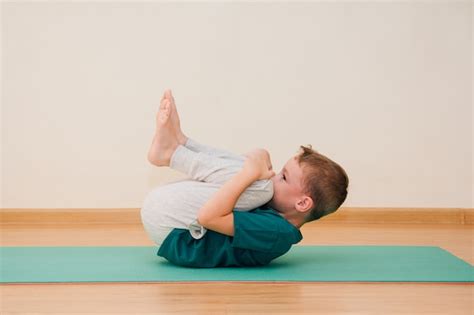 Premium Photo Cute Little Boy Is Learning To Do Yoga In The Gym