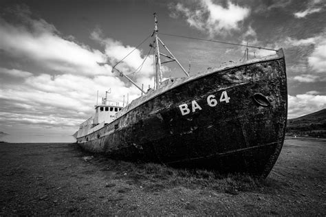 Grayscale Photography Of Abandoned Cargo Ship On Field · Free Stock Photo