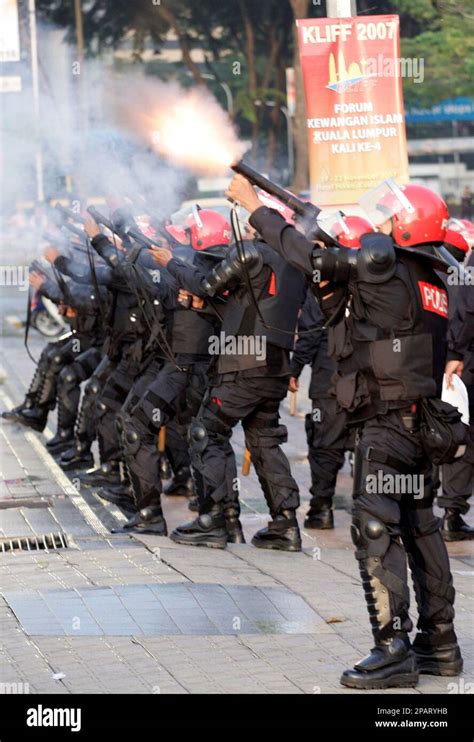 Malaysian Riot Police Officers Fire Tear Gas During A Street Protest By Ethnic Indians In Kuala