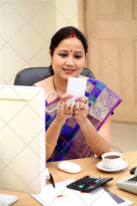 traditional indian business woman texting at office desk photos by canva
