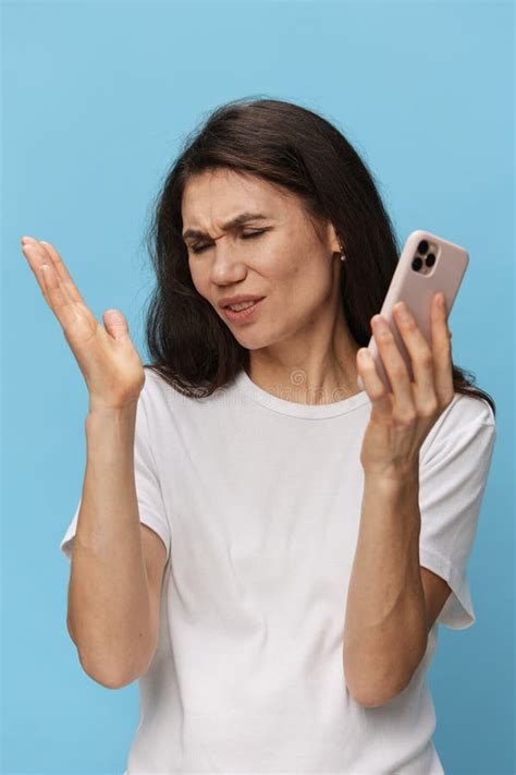 A Happy Joyful Woman Stands With A Phone In Her Hands Spreading Her Arms To The Sides