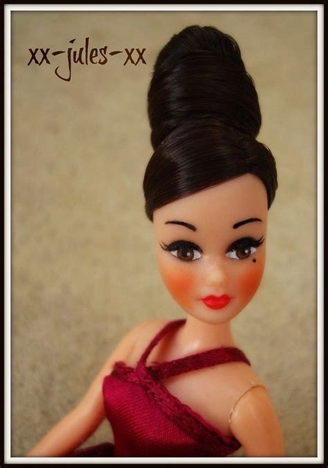A Close Up Of A Doll Wearing A Red Dress