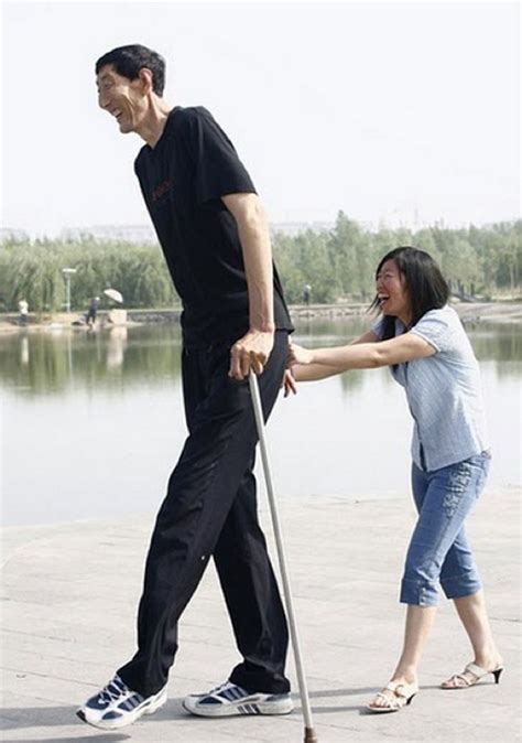 A Man Walking Next To A Woman With A Cane On The Sidewalk Near A Body